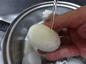 流水に当て殻を剥く